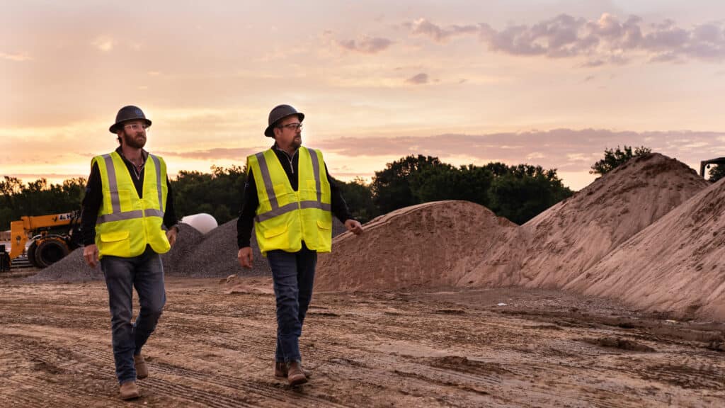Construction workers walking at site during sunset - Rupe Companies commercial construction and real estate development in Tulsa